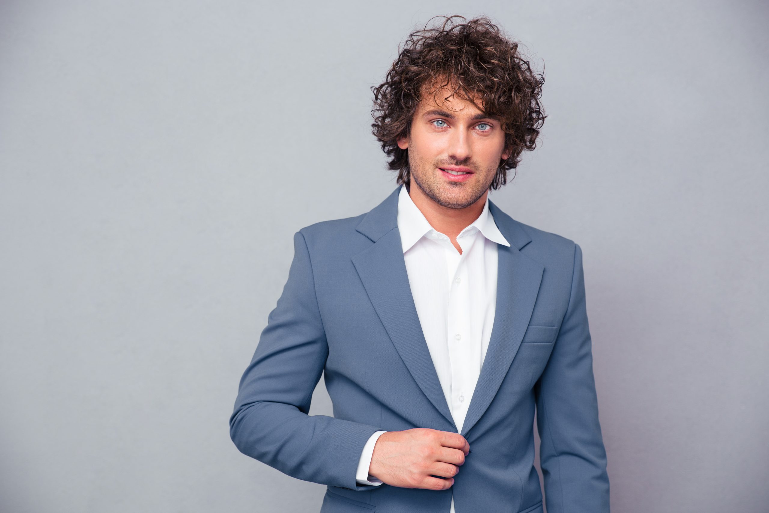 businessman with curly hair looking at camera scaled