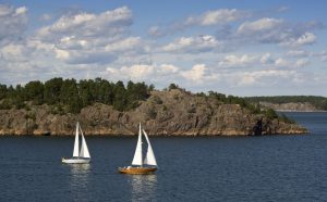 sailboats along a rocky coast