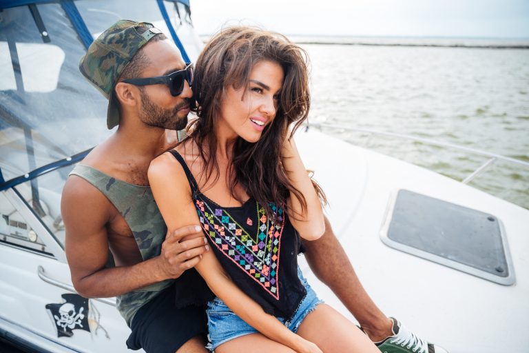 Beautiful couple smiling and embracing on yacht